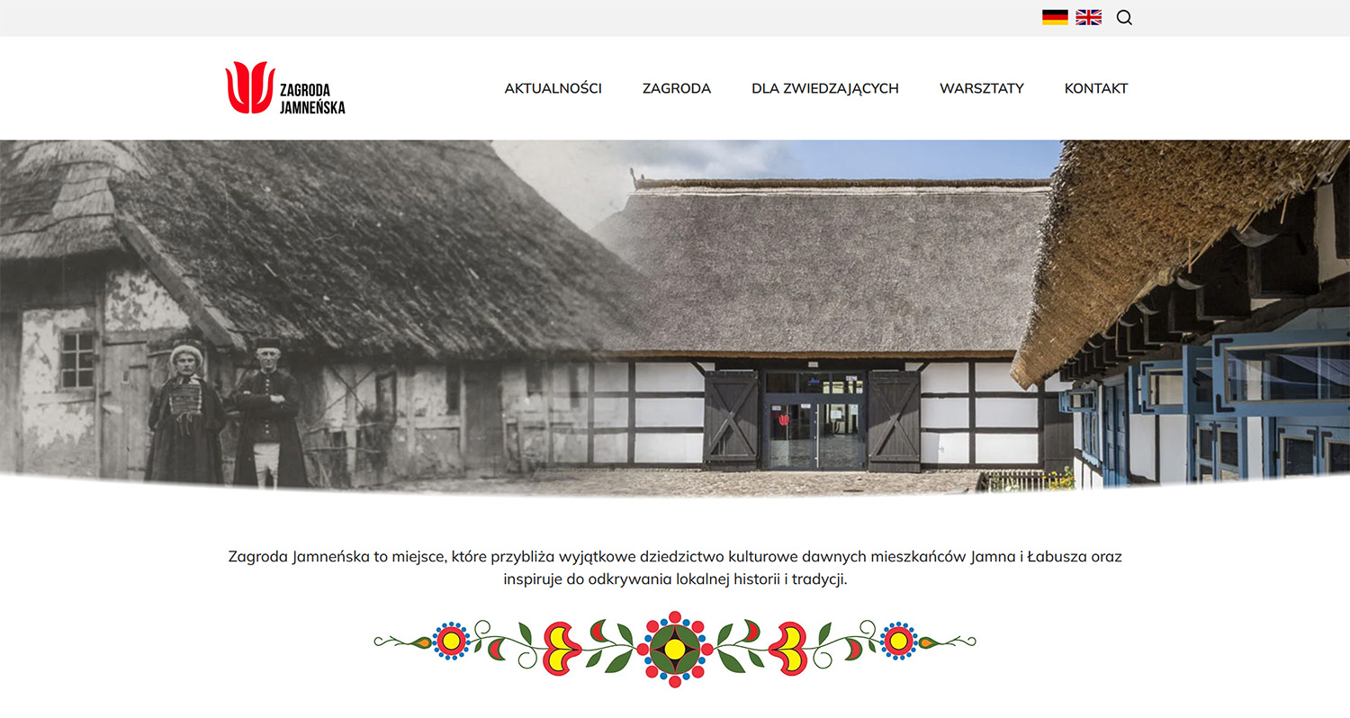 Zrzut ekranu strony internetowej Zagrody Jamneńskiej z nagłówkiem, menu nawigacyjnym oraz dużym zdjęciem tradycyjnej zabudowy z elementem archiwalnej fotografii po lewej stronie.